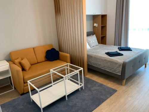 Cette petite chambre comprend un canapé et un lit. dans l'établissement Comfort Plaza Residence Studio (Lujerului), à Bucarest