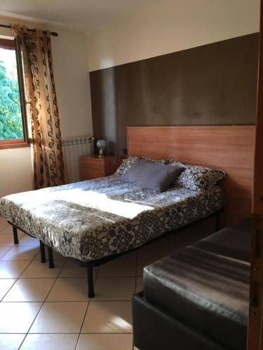 デセンツァーノ・デル・ガルダにあるantonellagardalakeのベッドルーム1室(木製ヘッドボード付きのベッド1台付)