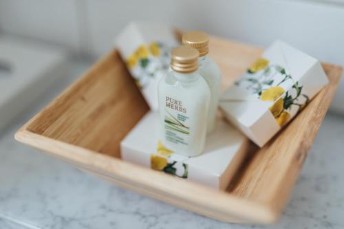 a wooden tray with a bottle of moisturizers and soap at Hotel de France Wiesbaden City in Wiesbaden