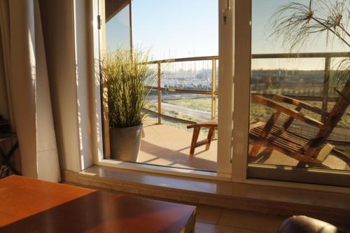 a window with a view of a balcony with a bench at Appartement aan de yachthaven in Nieuwpoort