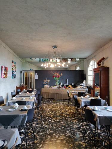 a dining room with tables and chairs and a chandelier at Hotel Castello S. Antonio in Lazise