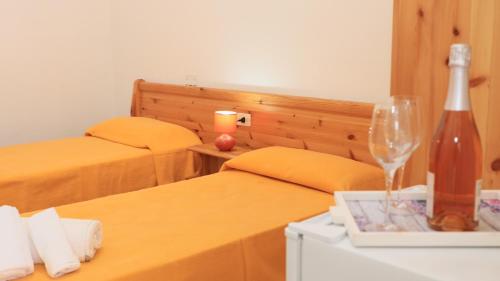a hotel room with two beds and a bottle of wine at Villaggio Elisena in Vieste