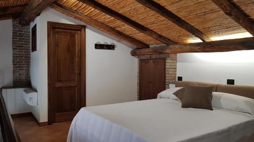 een slaapkamer met een wit bed en een houten plafond bij La Gelsomina - Etna in Presa