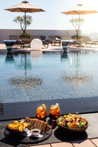 a tray of food next to a swimming pool at The Stanley in Athens