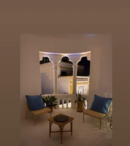 a room with two chairs and a table and a mirror at Casarão AL in Olhão