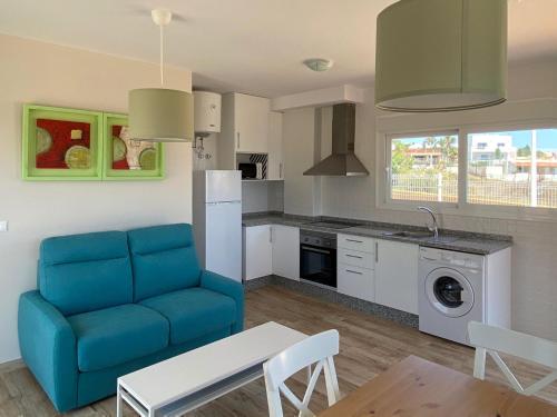 a living room with a blue couch and a kitchen at Mda Playa del Cantal in Mojácar