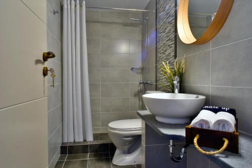 a bathroom with a sink and a toilet and a mirror at House in Εndless green - Arethousa, Ikaria in Évdhilos