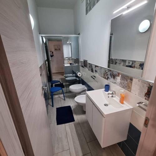 a bathroom with a sink and a toilet and a mirror at Bilocale Conti in Santa Teresa Gallura