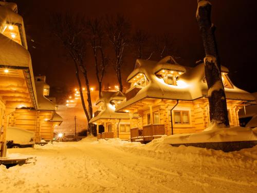 a house covered in snow at night at Osada Harenda in Zakopane