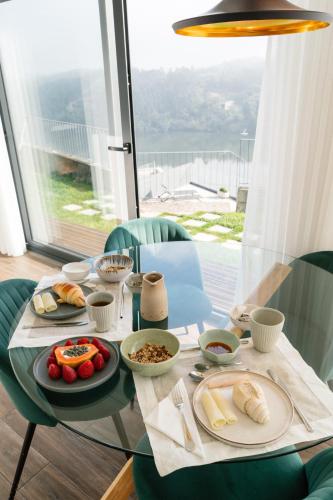 a glass table with food on top of it at Quinta do Pomar Maior Douro - Porto Carvoeiro in Porto Carvoeiro