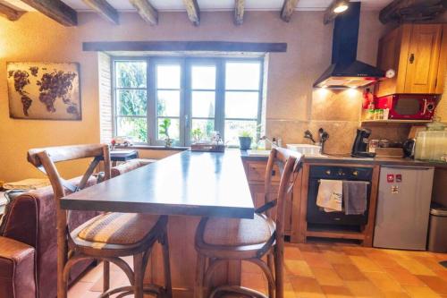 a kitchen with a table and some chairs in it at Longère Touraine Anjou in Hommes