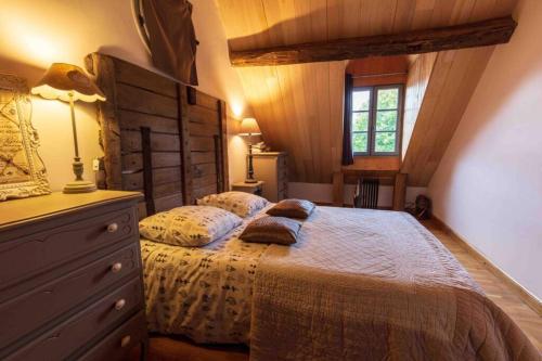 a bedroom with a bed and a dresser and a window at Longère Touraine Anjou in Hommes