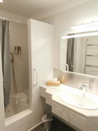 une salle de bain blanche avec un lavabo et une douche dans l'établissement Agachoun, à Aubagne