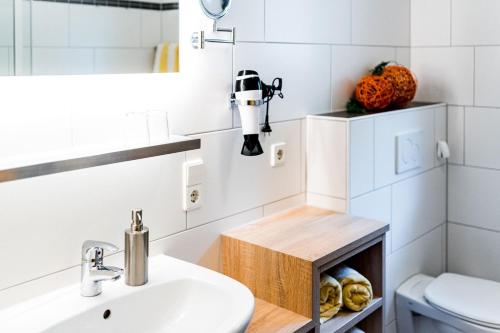 a bathroom with a white sink and a robot on a shelf at Paradies im Schwarzwald in Bad Peterstal-Griesbach