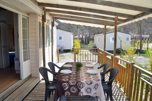 a table on the porch of a house at Camping Tikayan La Célestine in Beynes