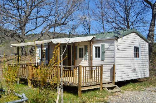 Une petite maison blanche dans les bois dans l'établissement Camping Tikayan La Célestine, à Beynes