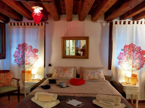 a bedroom with a bed and two windows and a mirror at Suite Ai Leoni in Venice