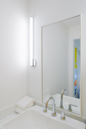 a bathroom sink with two faucets and a mirror at The Gallatin in Nashville