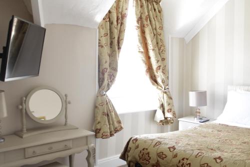 A bed or beds in a room at Clifton Villa Guest House 