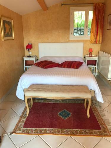 - une chambre avec un grand lit et un tapis rouge dans l'établissement Les Trèfles, à Hyères