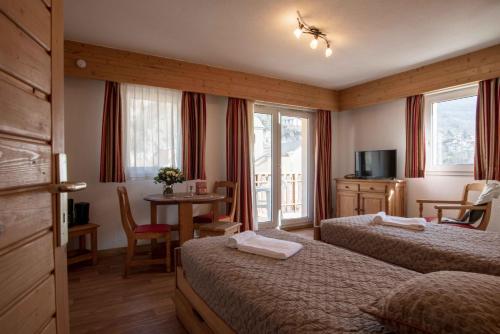 Cette chambre comprend 2 lits et une table. dans l'établissement Résidence Eureca, à Brides-les-Bains