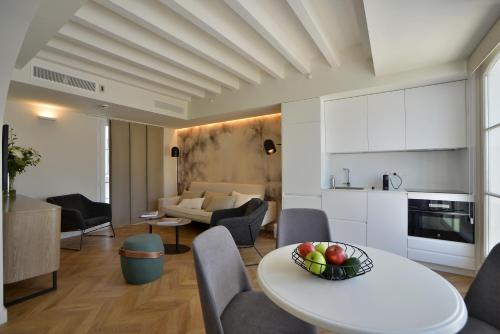 a kitchen and a living room with a table and chairs at Plaza Mina Suites - Adults Recommended by Luxury Suites Cadiz in Cádiz