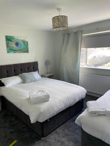 a bedroom with a large bed and a window at Causeway View large pet friendly seafront house, see dolphins in Portrush