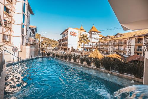 a swimming pool in a city with buildings at Hotel Recanto Do Rouxinol in Piratuba