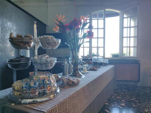 a table with a vase of flowers on top of it at Hotel Castello S. Antonio in Lazise