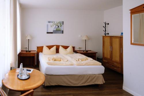 a hotel room with a bed and a table at SCHULZENS Brauerei & Hotel in Tangermünde