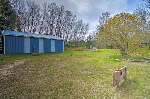 a blue building in the middle of a field at Pet-Friendly Charlevoix Cabin Walk to Lakefront! in Charlevoix