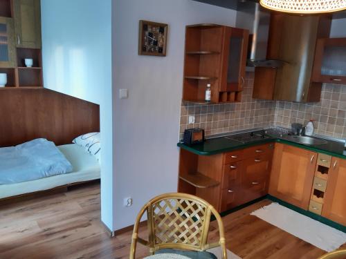 Una pequeña cocina con una cama en una habitación. en Polanica Centrum, en Polanica-Zdrój