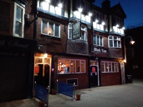 a brick building with a sign on it at night at Black Lion in Scarborough