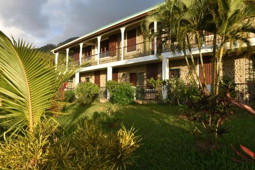 un gran edificio con un patio delante en King Room bed and breakfast main house, en Tanetane