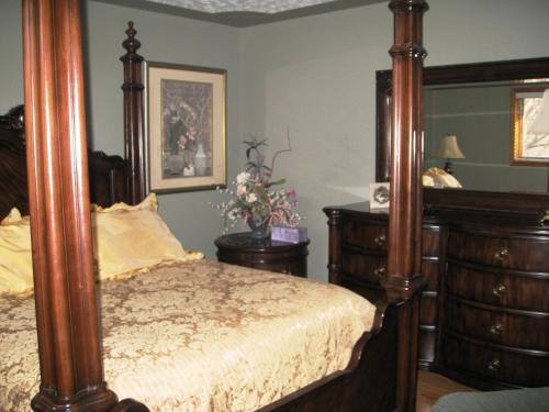 a bedroom with a canopy bed and two dressers at McDougall Lane Bed & Breakfast in Drumheller