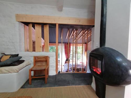 sala de estar con sofá y chimenea en La Fortance Paradis Naturel - Proche de la ville en Planfoy