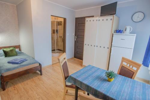 a room with a table and a bed and a dining room at PIKA Pokoje Gościnne in Władysławowo
