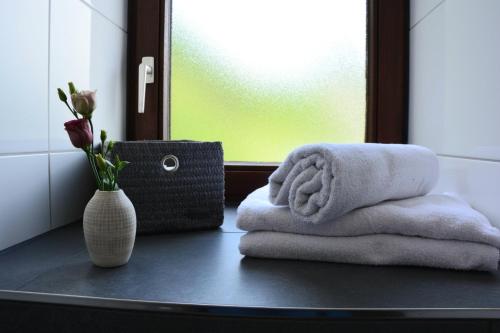 un bagno con due asciugamani e un vaso di fiori di Ferienwohnung Traumzeit a Cochem