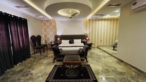 拉希姆亞爾汗的住宿－Golden Sand Hotel Rahim Yar Khan，卧室配有一张床和一张桌子及椅子
