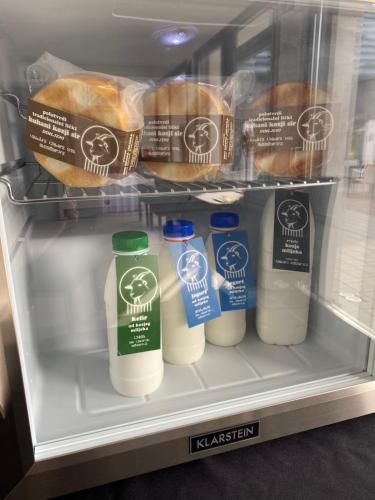 a refrigerator filled with bottles of milk and bread at Pansion Danica in Rastovača