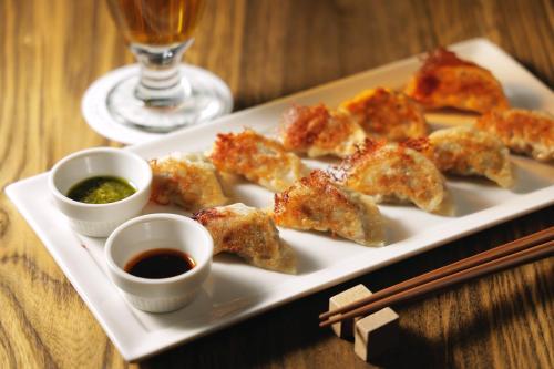 a plate of food with chopsticks and sauce on a table at Hotel Nupka in Obihiro