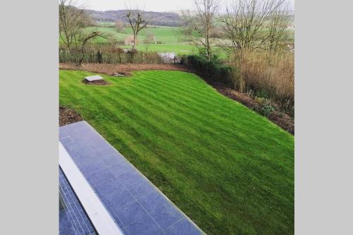 a yard with green grass and a walkway at Het Kastanjehuis in Orlitain