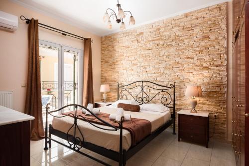 - une chambre avec un mur en briques et un lit dans l'établissement michael apartments, à Corfou