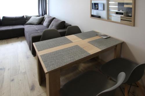 sala de estar con mesa y sofá en Apartament Navigare en Kołobrzeg