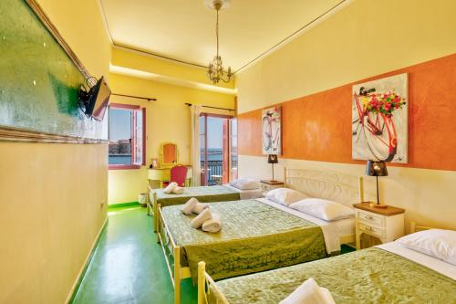 a hotel room with four beds in a room at Boutique Florence in Ermoupoli