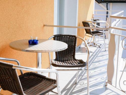 a patio with a table and chairs on a balcony at 5Rooms Frühstückspension in Sankt Stefan im Rosental