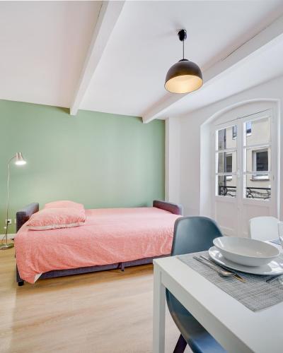 une chambre avec un lit et une table avec des chaises dans l'établissement Avignon With Love Appart Hôtel Avignon, à Avignon