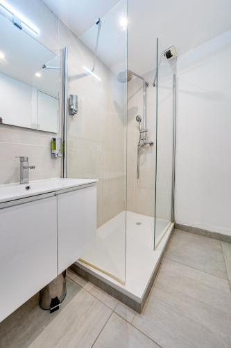 une salle de bain avec une douche en verre et un lavabo dans l'établissement Avignon With Love Appart Hôtel Avignon, à Avignon