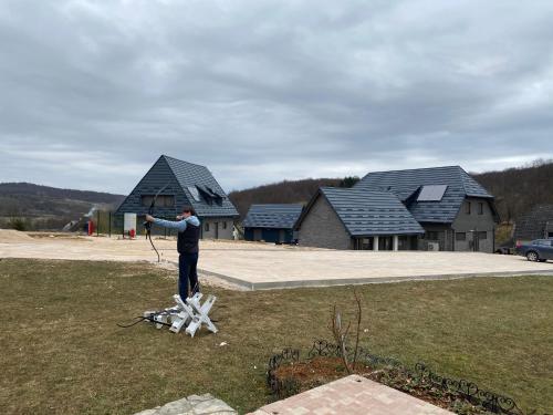 a man is flying a kite in a yard at Pansion Danica in Rastovača