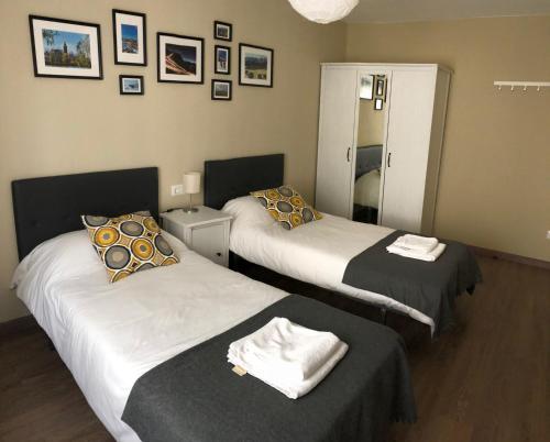 een kamer met 2 bedden en een spiegel bij Apartamento acogedor y familiar - WiFi+Chromecast in Puigcerdà